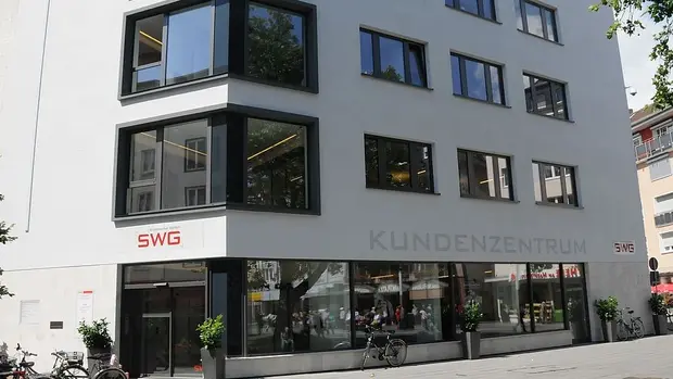 SWG-Kundenzentrum Das Bild zeigt ein modernes, mehrstöckiges Gebäude mit großen Fenstern. An der Fassade ist das Logo "SWG" und die Beschriftung "KUNDENZENTRUM" zu sehen.