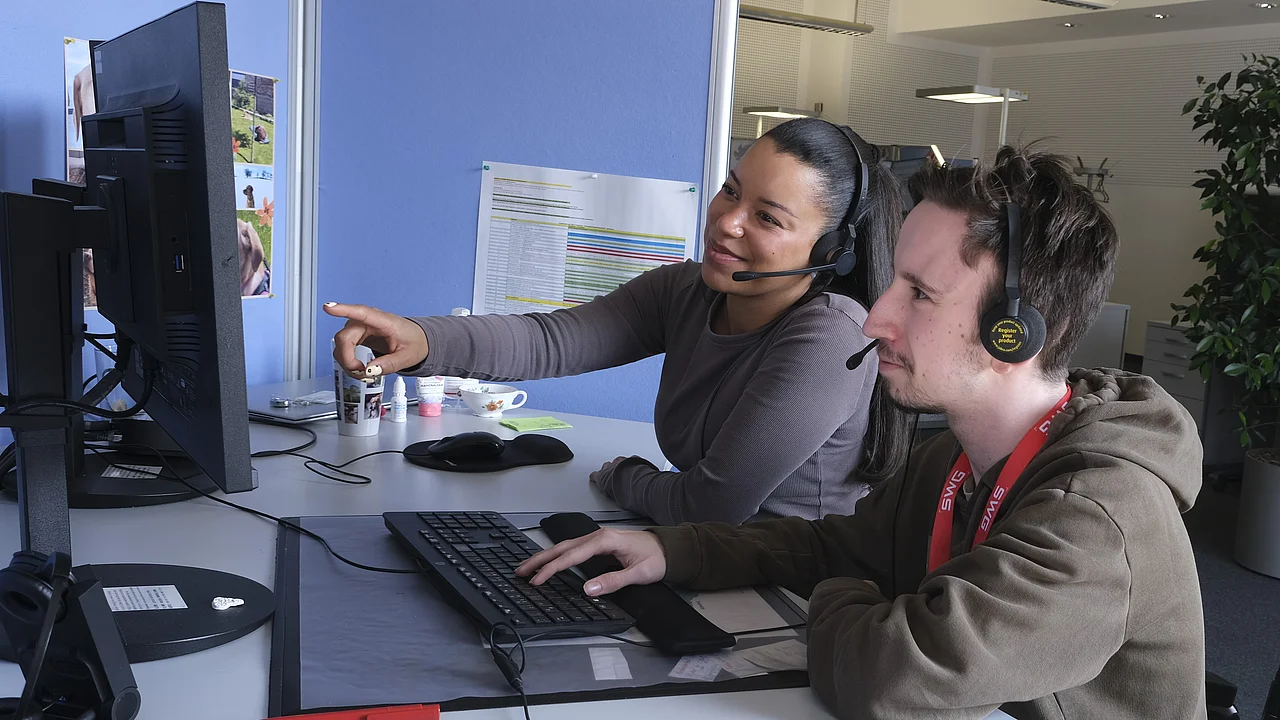 Two people together in front of a computer.