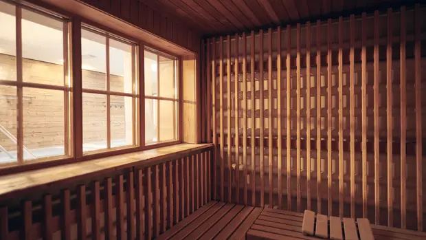 SWG-Sauna-mit Fenster Das Foto zeigt einen Ausschnitt aus einer Sauna mit einem Fenster mit Blick auf einen Blick auf den Badebereich.