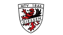 Ein Wappenschild mit einem roten Löwen und einem schwarzen Adler ineinander verschlungen. Oben steht der Text "MTV 1846" und unten "Giessen".
