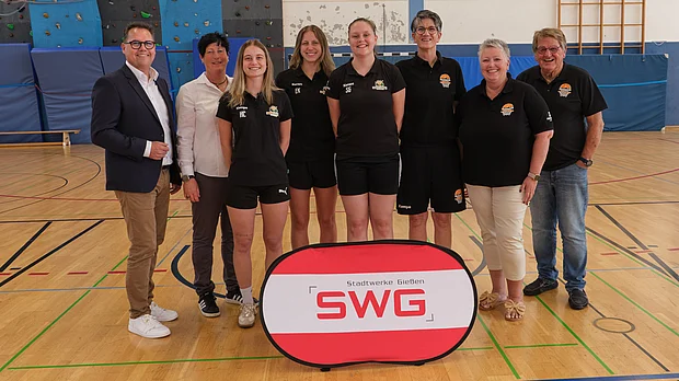Vertreter von SWG und Verein posieren in einer Sporthalle