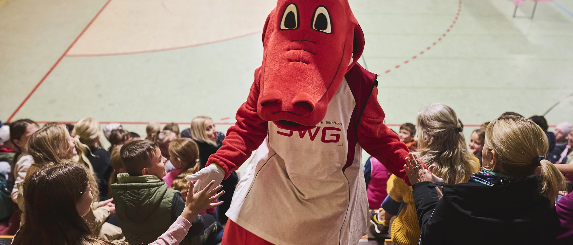 Das SWG-Maskottchen Fabius mit Kindern in der Schule