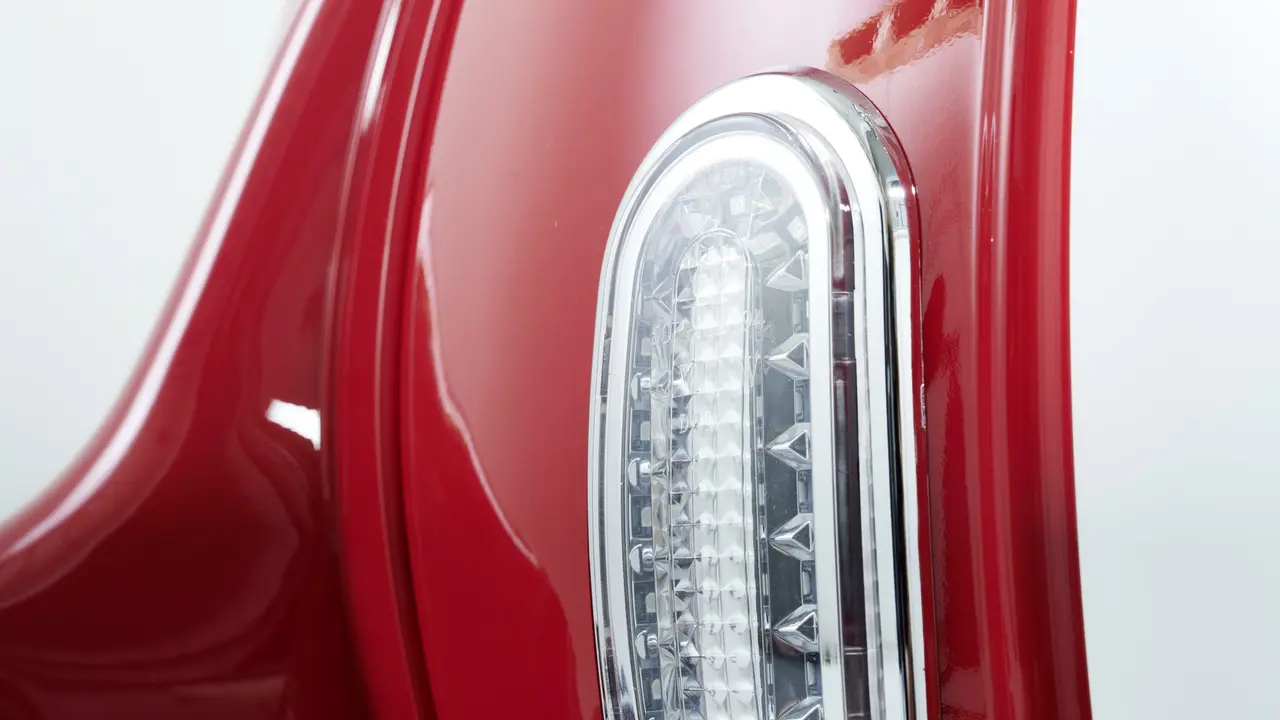  Nahaufnahme eines vertikalen, länglichen LED-Rücklichts an einem glänzend roten E-Retro-Roller. 