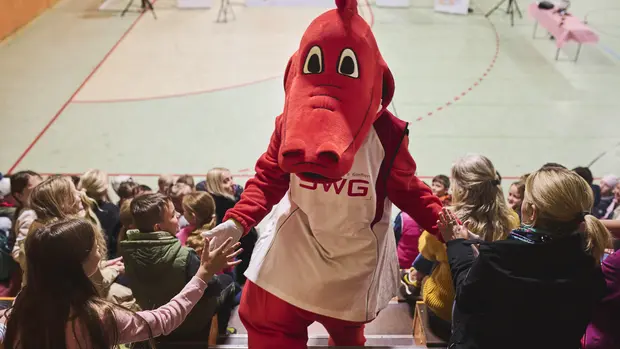 Das SWG-Maskottchen Fabius mit Kindern in der Schule
