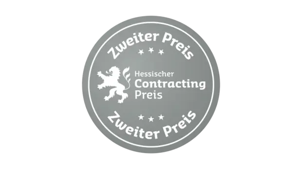 Silberfarbenes Siegel mit der Aufschrift „Hessischer Contracting Preis – Zweiter Preis“. In der Mitte ist ein stilisierter Löwe abgebildet, der von Sternen umgeben ist.